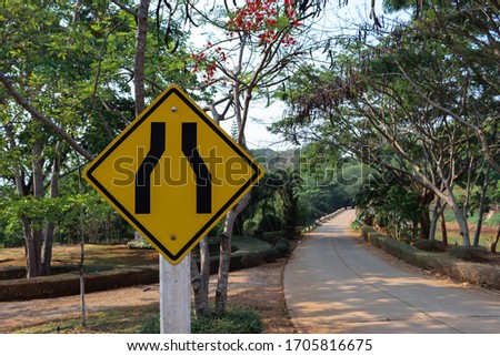 A sign indicating that the road ahead is a narrow path