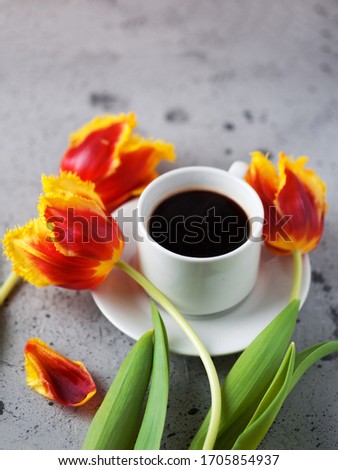 Good morning a Cup of hot espresso coffee, Tulip flowers on a stone gray table