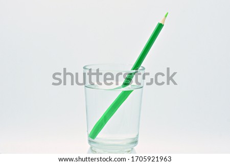 
Green colored pencil inside a glass of water, light refraction Royalty-Free Stock Photo #1705921963