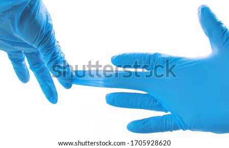 Hands wearing blue medical latex gloves Protection against flu, virus and coronavirus. Health care and surgical concept. Correct way of removing protective gloves in order to avoid touching the skin