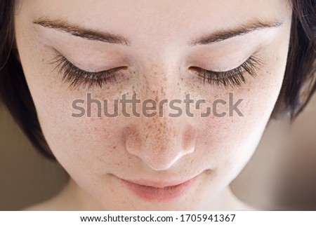 Portrait of a young girl with freckles without makeup. Royalty-Free Stock Photo #1705941367