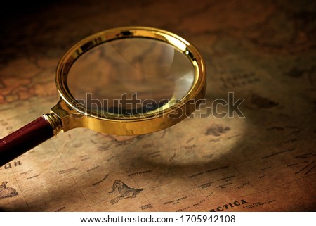 Magnifying glass and old navigation map.