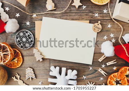 Christmas patter for postcard with dry fruits, craft paper, gift box, handmade christmas toys. top view on wooden desk.