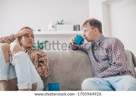 Serious young couple sitting together on sofa, talking about relationships, spending time together at home, focused wife listening to speaking husband, friends having conversation
 Royalty-Free Stock Photo #1705964926