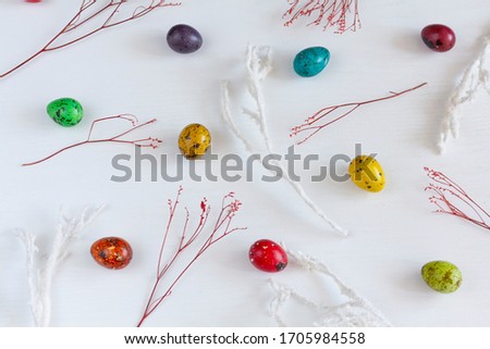 Colored quail eggs  on white wooden table. Easter table setting. Spring holiday. Flat lay. Top view. Free space.