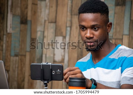 young man making a vlog, interacting with viewers, working from home, doing a live video chat Royalty-Free Stock Photo #1705994479