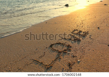 Love Beach Summer Holiday Hand Written on Sand with Sea or Ocean Water at Sunset. Travel Tourism Vacation Seascape Islands Resorts Couples Goals Romantic Honeymoon Happiness Banner Background Image. 