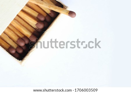Macro photo of an open matchbox with wooden matches on a white background.