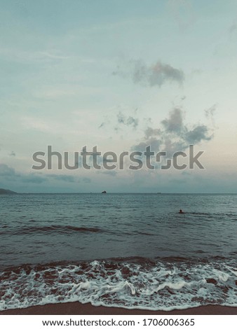 Beach view with a wave and some clouds without sun. Perfect for a beachside background