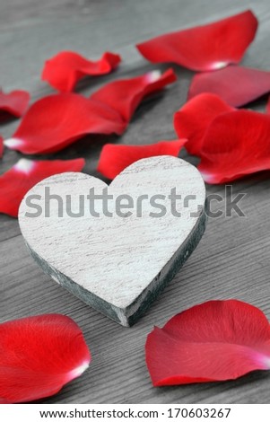 Valentines day background.  Heart and red roses petals on old wood. Holiday card.