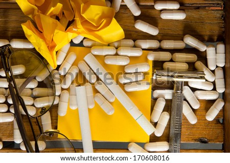 Capsule drug with yellow note and cigarette
