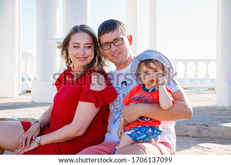 Young average family of three on vacation by the sea