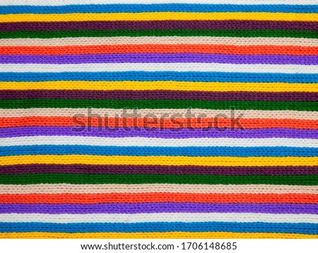 Knitted striped texture. Woolen fabric. Multi-colored ornaments - red, yellow, green, blue, white, brown, orange, purple.