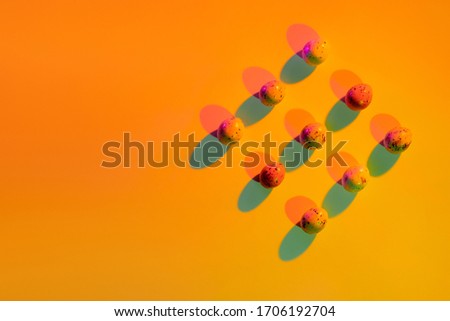 Easter quail eggs on the color bright orange background with shadows. Picture has copy space and minimalistic style. Trend creative food concept to the holiday. 