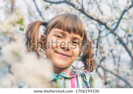 A child in the garden of flowering trees. Selective focus.