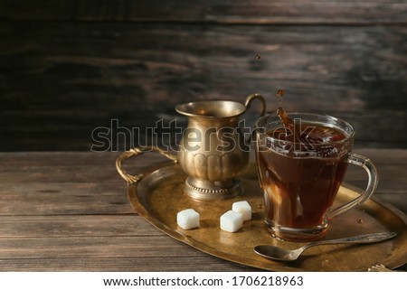 Splashing of coffee in glass cup on table