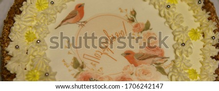 Home-cooked cake. The cake is decorated with birds of bullfinches and cream roses. Translation of the inscription in russian - Congratulations. The concept of home cooking.