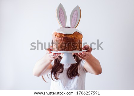 Portrait of gir holding Easter bread on stand in front of her