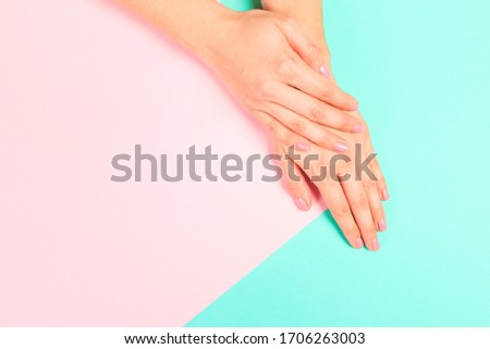 female  manicure. Beautiful young woman's hands on pastel   background