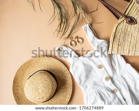 Women's summer straw hat, wicker bag, white sundress, sunglasses  and jewelry on a beige background. Copy space. Top view
 Royalty-Free Stock Photo #1706274889