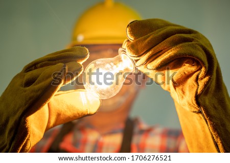 Electrician with light bulbs,Electrician Fixing the Light Inside Remodeled at home. Royalty-Free Stock Photo #1706276521