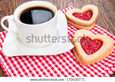 Coffee and cookies with jam on red napkin