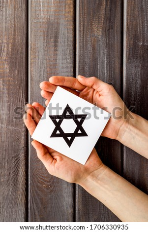 Star of David sign in hands - religion Judaisim symbol - on wooden table top view copy space