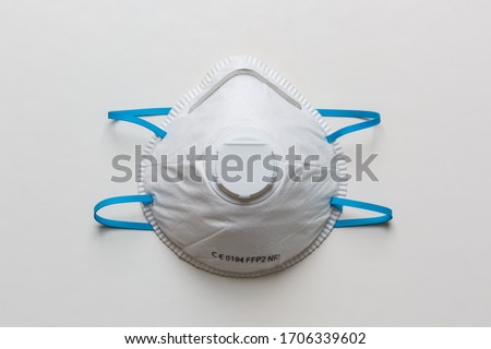 White FFP2, N95 respirator on a white table. Dust protection respirator or medical respiratory mask against the virus, top view. Royalty-Free Stock Photo #1706339602
