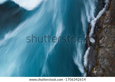 Long exposure of water in Hraunfossar waterfall, a waterfall formed by rivulets streaming over Hallmundarhraun, a lava field from volcano lying under the glacier Langjokull, 
