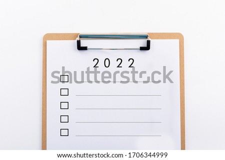 "2022" concept. Note pad and white paper  on white background, copy space