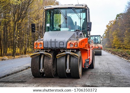 Industrial pavement machine laying new fresh asphalt.Fresh asphalt on highway construction site.