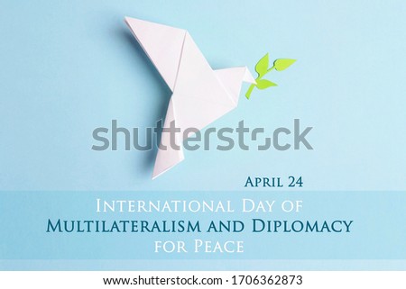 International Day of Multilateralism and Diplomacy for Peace,april 24. Paper origami dove of peace with olive branch on a blue background. 