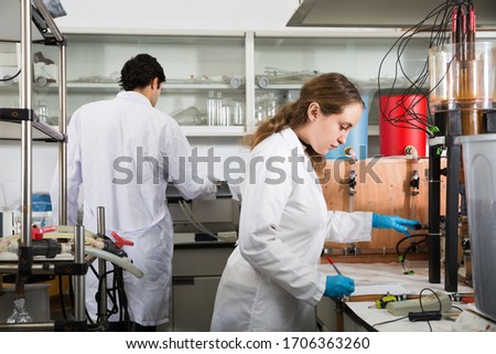 Adult female scientist using lab equipment during research in chemical laboratory