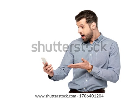 shocked businessman pointing with hand at smartphone isolated on white