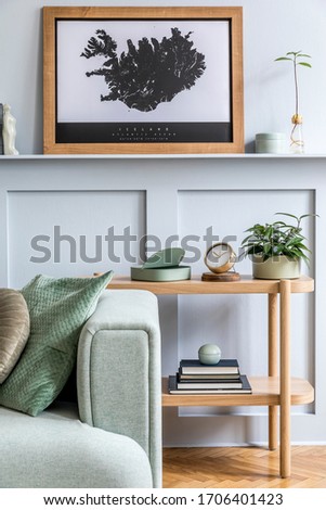 Minimalistic composition of living room with design sofa, coffe table, plant, books, decoration, pillows, plaid, carpet, wood paneling and elegant persoanl accessories in stylish home decor.