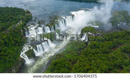Aerial view of Iguazu Falls, monumental waterfall system on Iguazu River surrounded by lush green jungle - landscape panorama of Brazil/Argentina border, South America Royalty-Free Stock Photo #1706404375