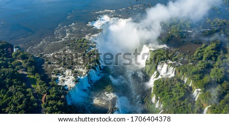 Aerial view of Iguazu Falls, monumental waterfall system on Iguazu River surrounded by lush green jungle - landscape panorama of Brazil/Argentina border, South America Royalty-Free Stock Photo #1706404378