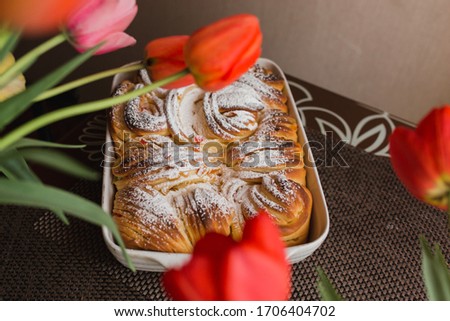 Easter kraffin with raisins, candied fruit, powdered sugar and a bouquet of tulips. Homemade Easter Baking