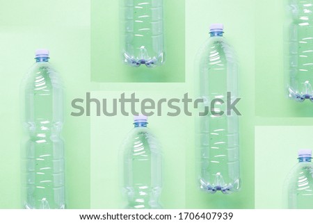 an artsy minimalistic compostion of empty plastic bottles against a pastel light green background, flat lay, studio shot
