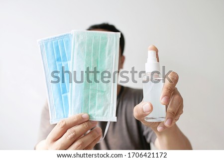 Alcoholic solution spray and face mask, Spray with disinfection alcohol for disinfecting hands against coronavirus or virus bacteria Royalty-Free Stock Photo #1706421172