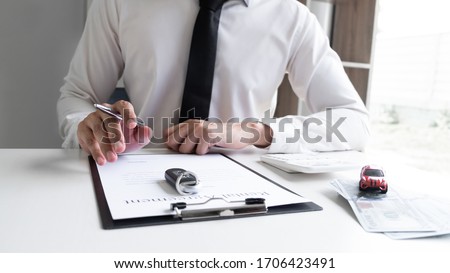 Car sales representative is calculating the rental fee of car rental agreement in the office, Car rental concept.
