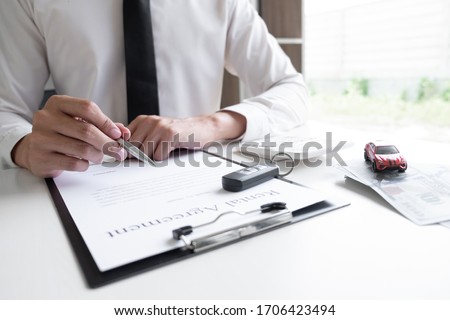 Car sales representative is calculating the rental fee of car rental agreement in the office, Car rental concept.