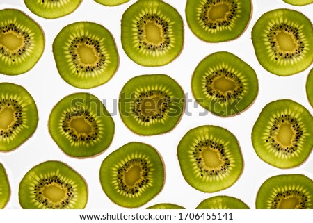 a beautiful image of an interesting pattern detail of kiwi fruit slices against a bright white background, flatlay