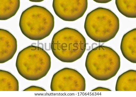 a beautiful image of an interesting pattern close up of sliced zucchini vegetables, against a bright white background, flatlay