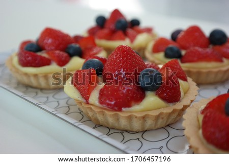 Delicious strawberry blueberry pie, tart with pudding with kitchen background