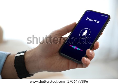 Man using voice search on smartphone indoors, closeup