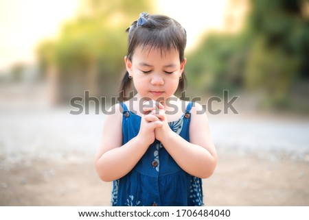 A cute little Asian girl prayed to God in the morning. The concept of prayer for faith, spirit, and religion