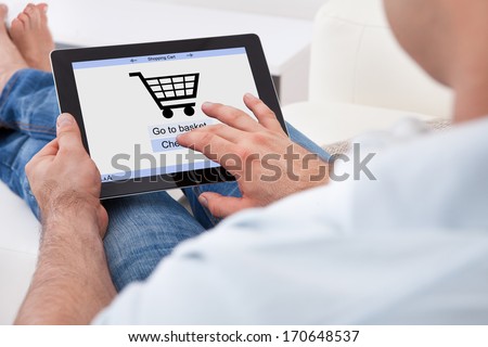 Close-up Of Man Shopping Online With Digital Tablet