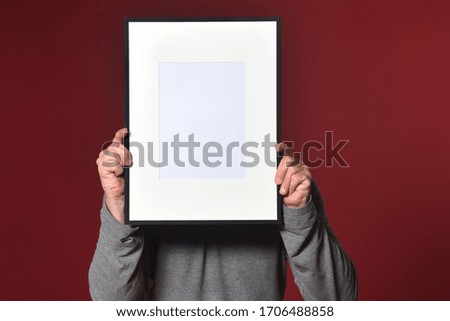 holding a frame on red background