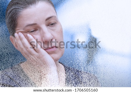 Fibromyalgia or chronic fatigue syndrome: exhausted woman falling asleep in the office, particle dispersion effect. Royalty-Free Stock Photo #1706505160